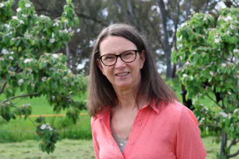 Alice Saville - a Community Worker standing outside in the garden. 