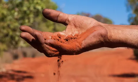 Hand filtering red sand