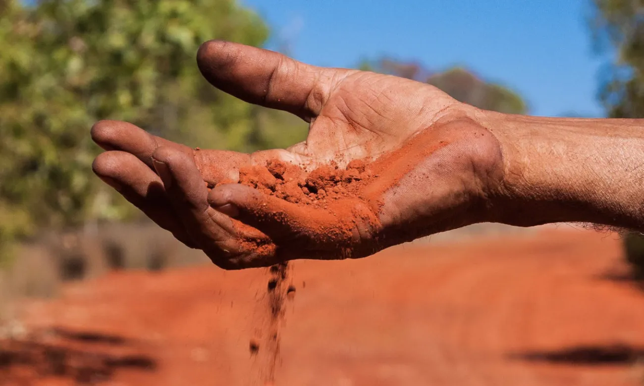 Hand filtering red sand